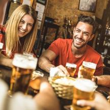 eine Gruppe von Leuten sitzt in einer Bar und trinkt Bier
