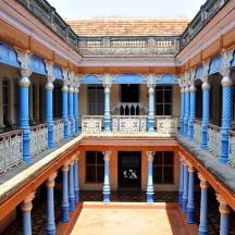 an old building with blue columns and a balcony