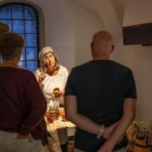 eine Gruppe von Menschen steht um eine Frau in einem Raum herum