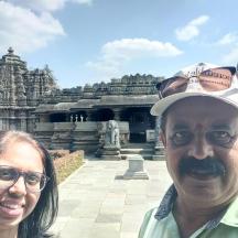 a man and a woman standing in front of a temple