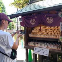 a woman taking a picture of a hot dog stand