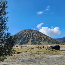 a group of people standing in front of a mountain
