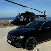 un cotxe negre aparcat al costat d'un helicòpter
