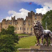 a statue of a lion in front of a castle