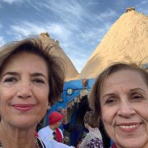 two women posing for a picture in front of a pyramid
