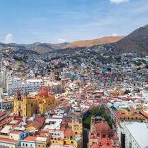 an aerial view of a city with buildings and mountains