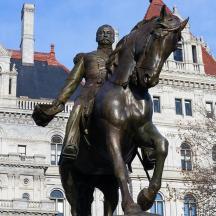 statua mężczyzny na koniu przed budynkiem