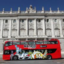 a red double decker bus parked in front of a building