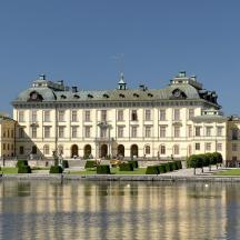 a large building with a pond in front of it