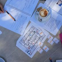 et bord med papirer og en kop kaffe og en pen