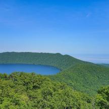 a lake in the middle of a hill with trees