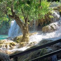 una donna seduta su una staccionata di fronte a una cascata
