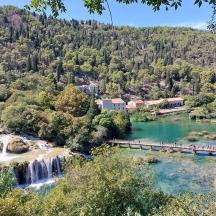 un treno che viaggia su un fiume con una cascata
