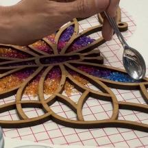 a person holding a spoon over a plate with glitter