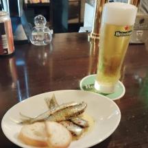 en tallerken fisk og et glas øl på et bord