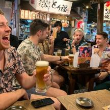 a group of people sitting in a bar drinking beer