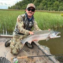a man sitting in a boat holding a fish