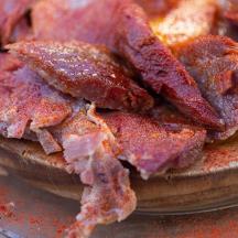 en bunke bacon, der ligger oven på en tallerken
