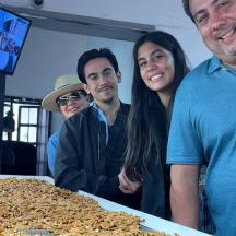 en gruppe mennesker, der står ved siden af et bord med mad