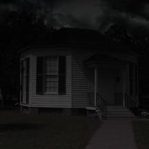 a black and white photo of a house at night