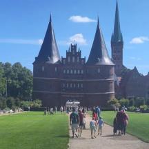 eine Gruppe von Menschen, die vor einem Schloss spazieren gehen