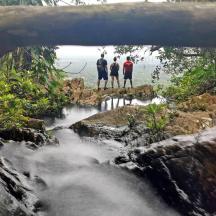 tres persones dempeus en un pont sobre un riu