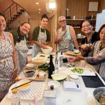 a group of people standing in a kitchen preparing food