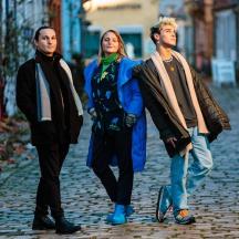 trijų žmonių grupė, einanti gatve