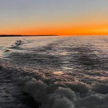 a boat in the water at sunset