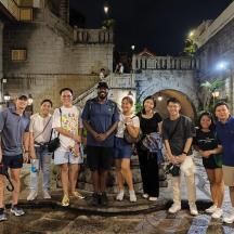 a group of people posing for a picture in an alley