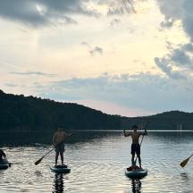 en gruppe på tre mænd paddleboarder på en sø