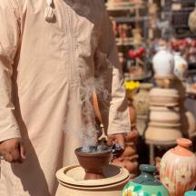 a man in a pottery shop with a potter working on a vase
