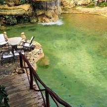 a patio with a table and chairs in a pond