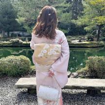 a woman in a kimono standing in front of a pond