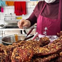 a person preparing food in a kitchen with a bunch of meat