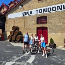 a group of people standing in front of a building with a bike