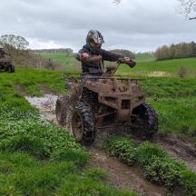a person riding a four wheeler on a muddy trail