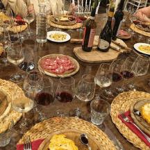 a long table with many plates of food and wine glasses