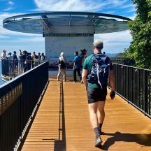 a man walking on a bridge with a backpack