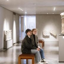 two people sitting in front of a museum exhibit