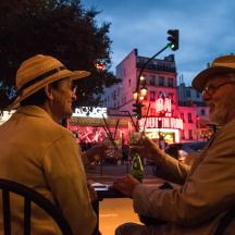 two older men sitting at a table with drinks