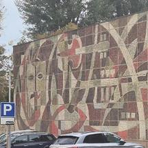 ένας μωσαϊκός τοίχος με αυτοκίνητα παρκαρισμένα σε ένα πάρκινγκ