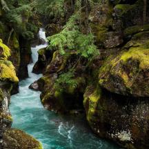 a waterfall in the middle of a river between rocks