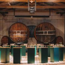 una stanza con un mucchio di tavoli e botti di vino