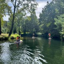 eine Gruppe von Menschen auf Paddle-Boards in einem Fluss