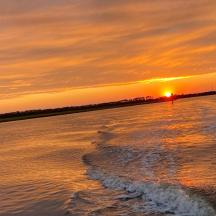 a sunset over a body of water with the ocean
