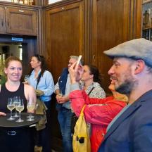 a group of people standing in a room with wine glasses