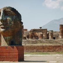 a statue of a head in front of a building
