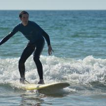 mężczyzna jadący na desce surfingowej na fali w oceanie