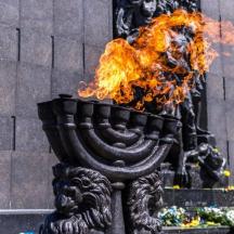 a statue with fire in front of a building